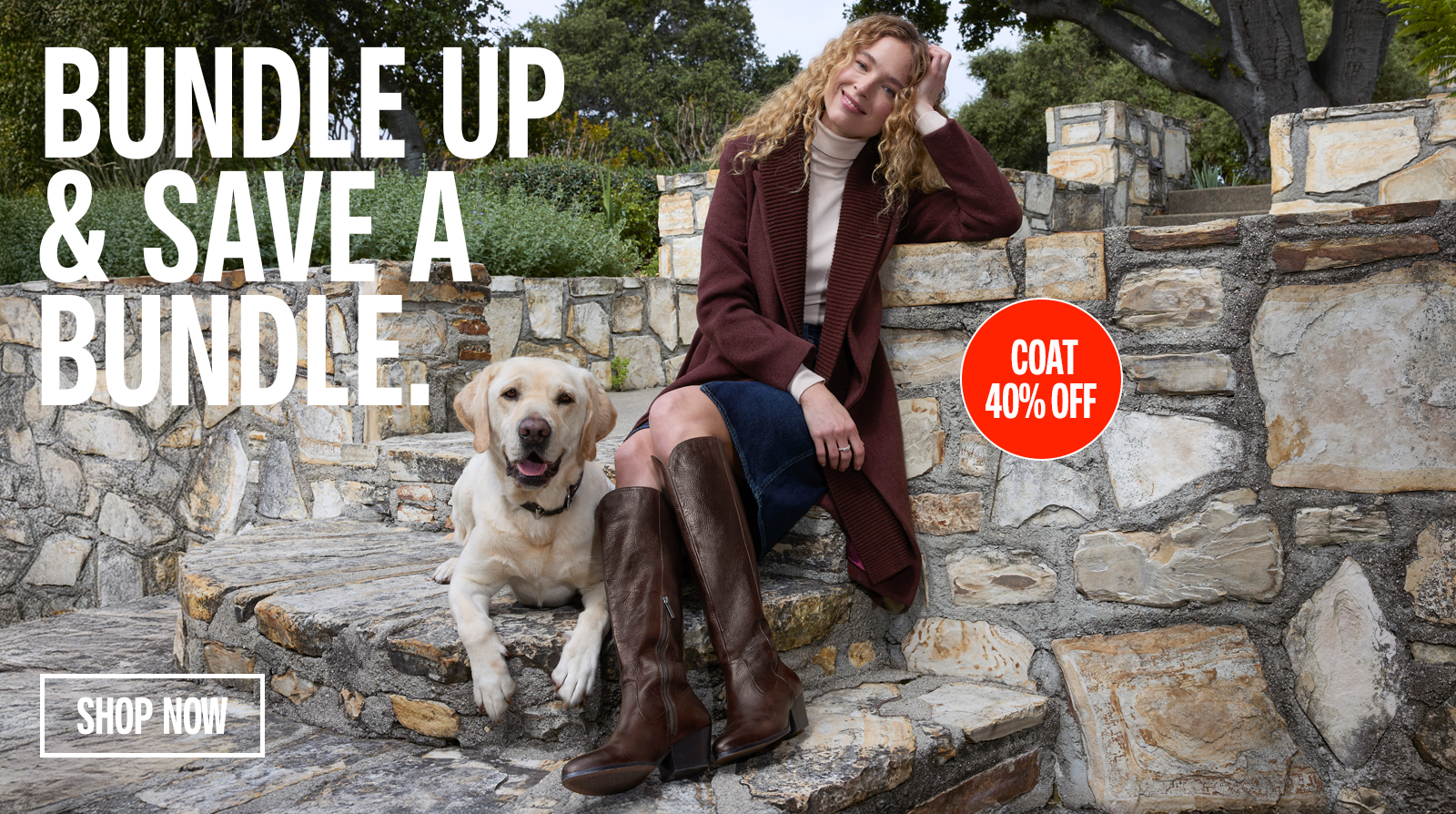 Woman sitting on stone steps wearing a coat, skirt, and boots with an english cream golden retreiver laying next to her.