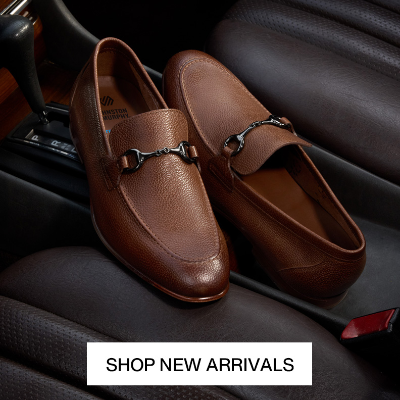 A pair of brown men's dress loafers in a car's front seat with a Shop New Arrivals button at the bottom of the image.