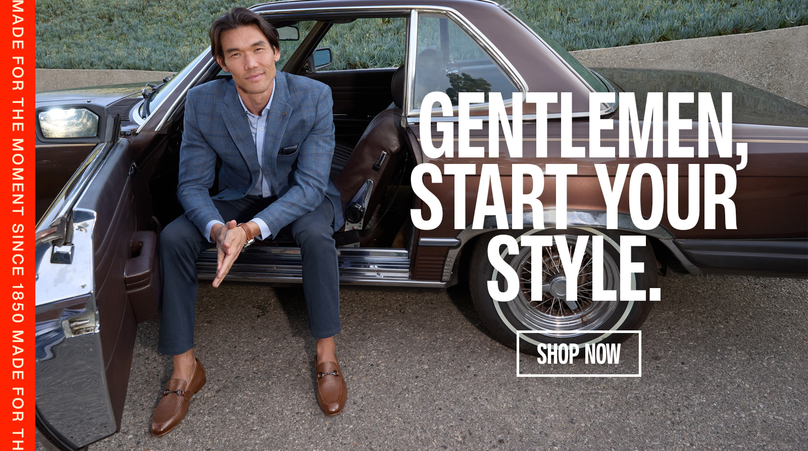 Man dressed in a blue blazer outfit from Johnston & Murphy sitting in a vintage car with the words 