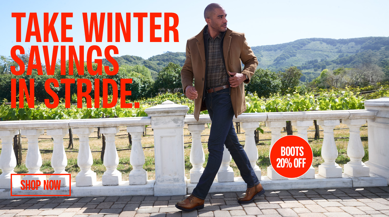 Man in plaid shirt and denim jeans with a brown coat on walking outside near a vineyard with sale pricing messaging overlaying the image.